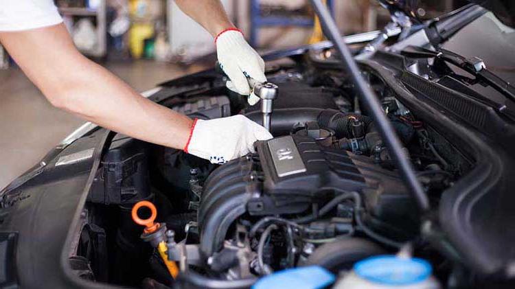 Mechanic working under a car hood.