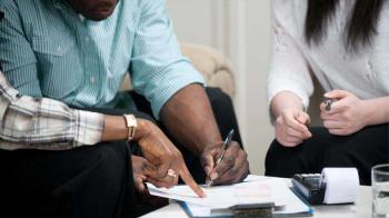 A tight shot of hands signing a rental lease.